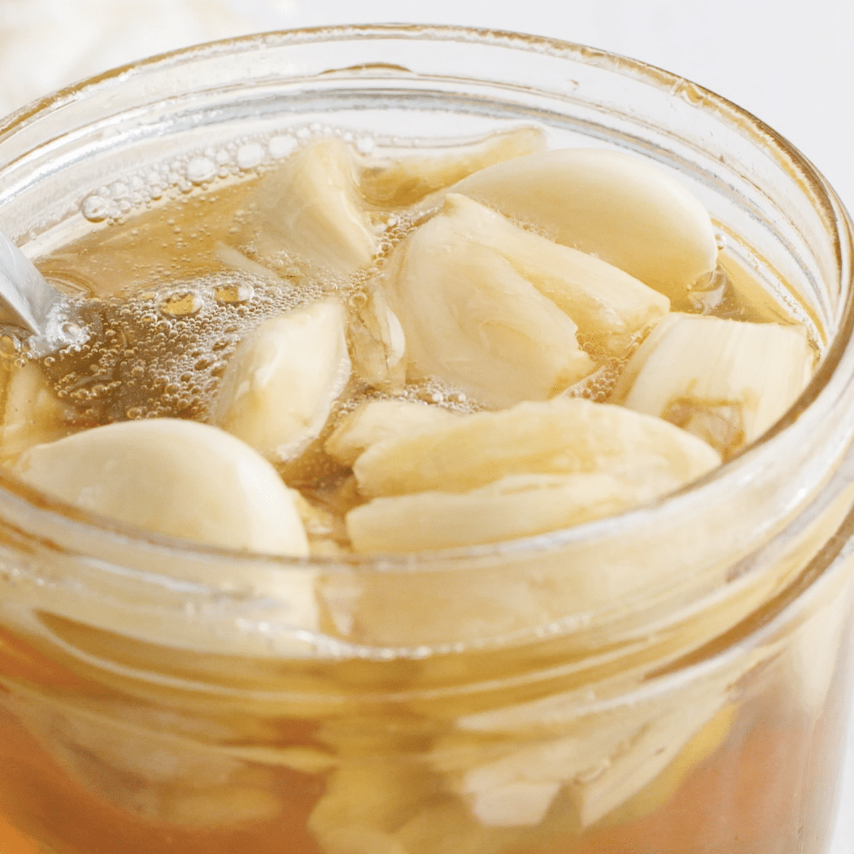 Close up view of honey garlic in a mason jar