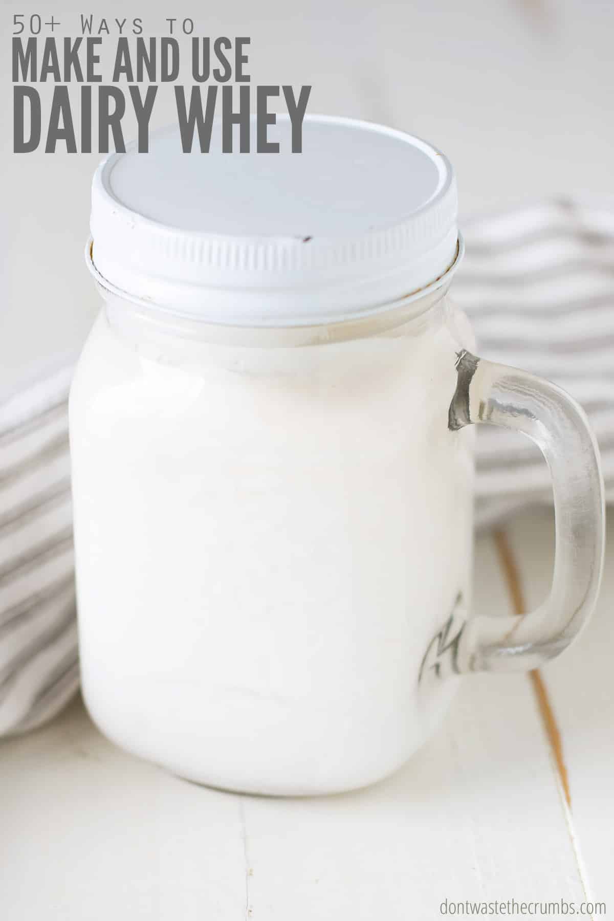 Mason jar with handle and lid with dairy whey. Text overlay reads "50+ Ways To Make And Use Dairy Whey" This list of 45+ practical uses for whey will make you think twice before pouring it down the drain!