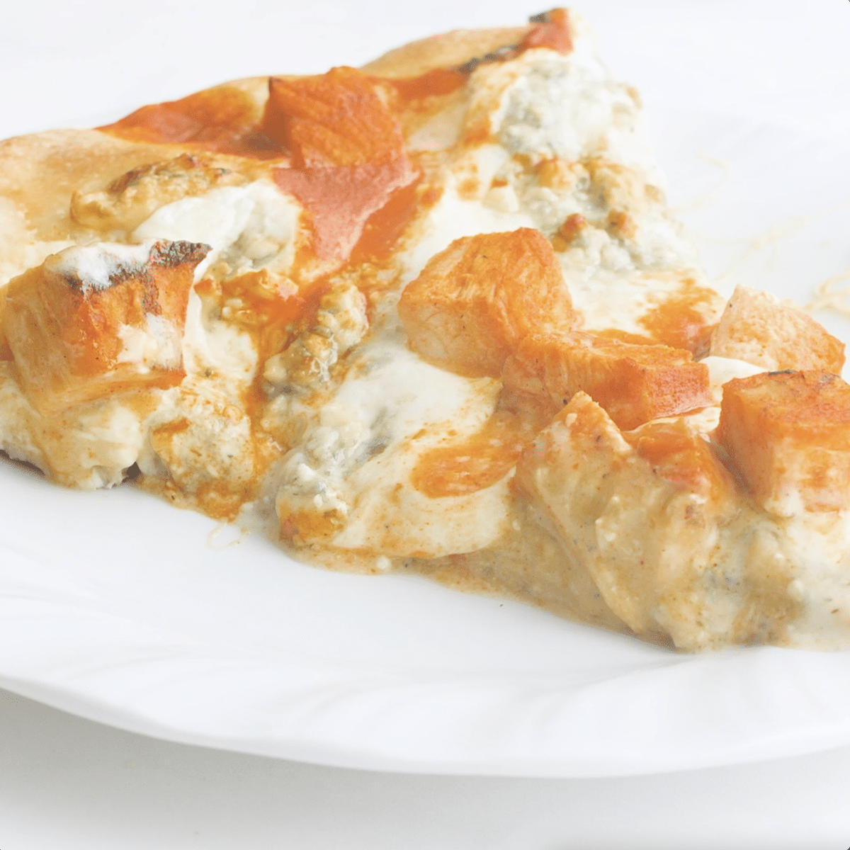 Slice of buffalo chicken pizza on a white plate.
