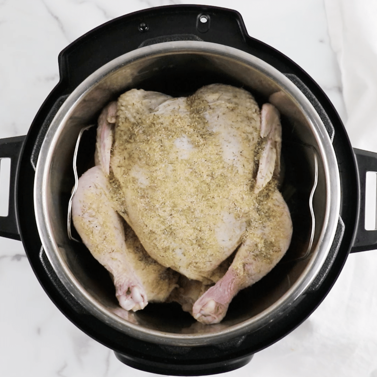 Seasoned raw whole chicken in an Instant Pot
