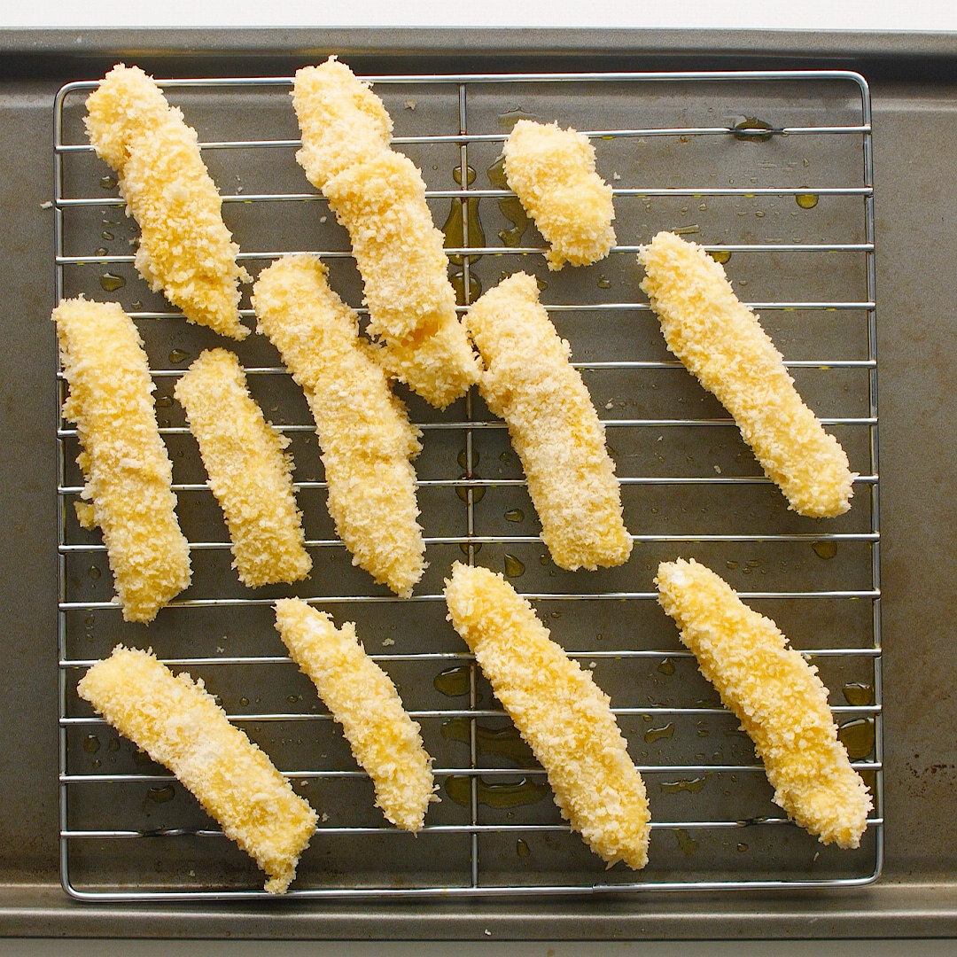 Homemade fish fingers are on a cooling wire rack