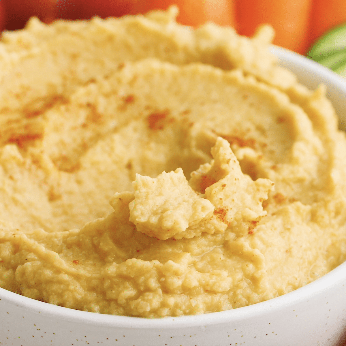 Close up view of hummus in a white bowl