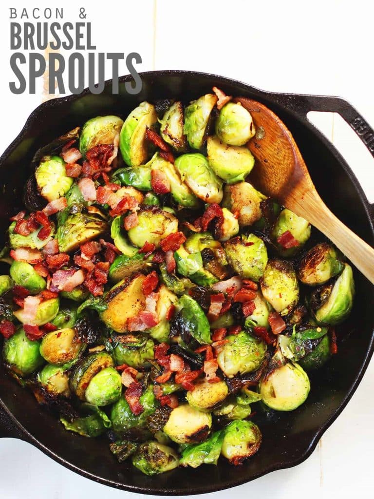 A cast iron skillet full of brussel sprouts with bacon and a wooden spoon. Text overlay reads "Bacon & Brussel Sprouts"