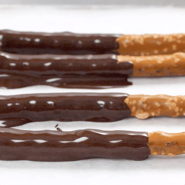 Up close view of four chocolate covered pretzels.