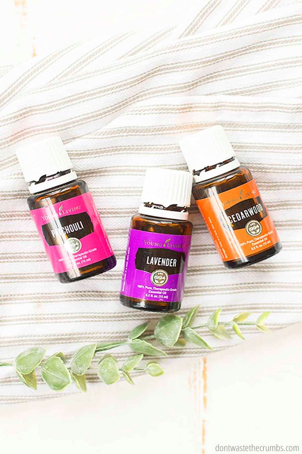 Patchouli, lavender, and cedarwood oils from Young Living lay on a striped towel.