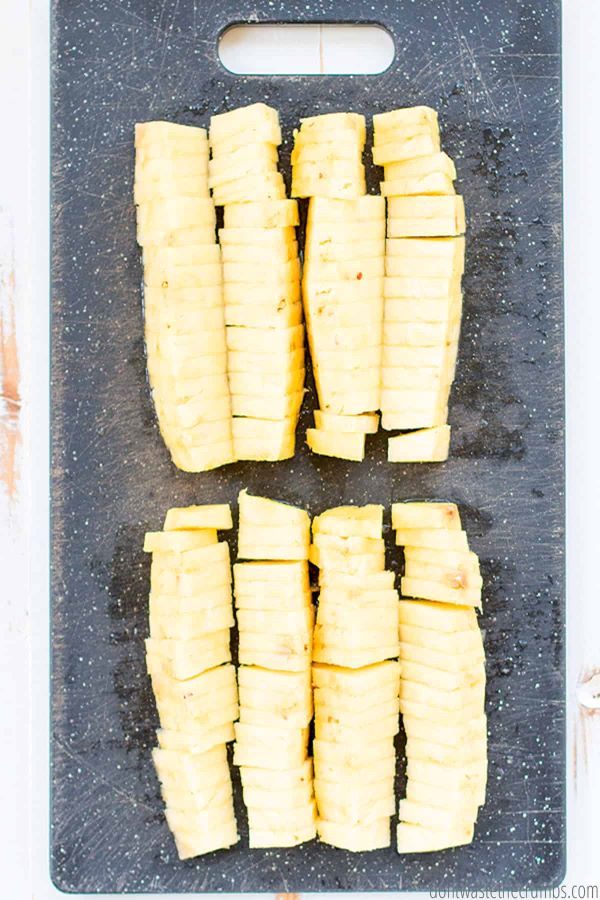 Many slices of freshly cut pineapple on a cutting board. Ready to serve and eat!