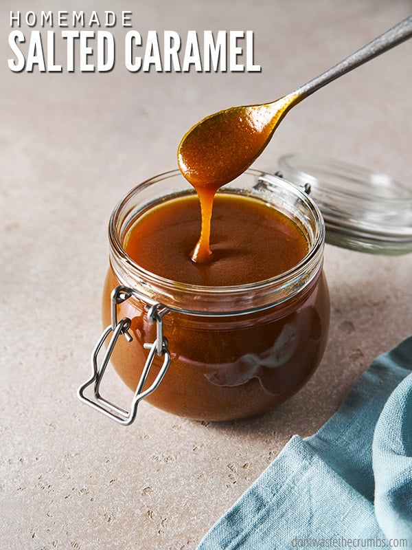 Container with homemade salted caramel with a spoon dipping into it. Text overlay reads, "Homemade Salted Caramel".